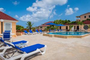 una piscina resort con tumbonas y una piscina en Villa by the sea, en Five Islands Village