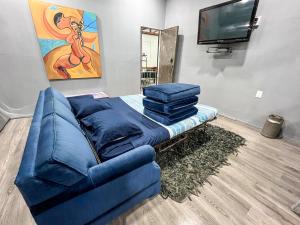 ein Wohnzimmer mit einem blauen Sofa und einem TV in der Unterkunft Lovely Loft 10 min from downtown - free parking in San Luis Potosí