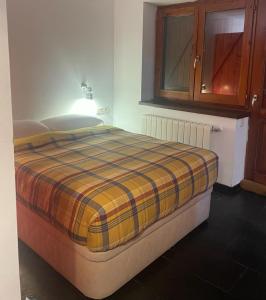 ein Bett mit einer karierten Decke auf einem Zimmer in der Unterkunft Zoe in Vilamós