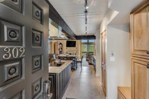 a hallway leading to a kitchen with a long counter at Interlude Condominiums 3-Bedroom Unit 302 in Snowmass Village