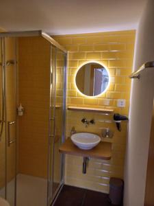 a bathroom with a sink and a glass shower at Gästezimmer im Dorfzentrum in Rothenthurm