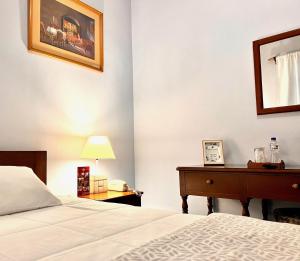 1 dormitorio con 1 cama y escritorio con lámpara en El Balcon Hostal Turistico, en Arequipa