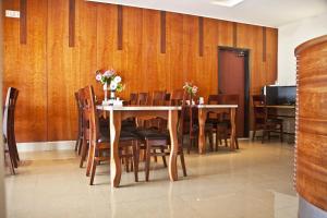 comedor con paredes de madera, mesa y sillas en Hotel Suites Bat Yam, en Bat Yam
