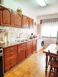 a kitchen with wooden cabinets and a sink at Golden wave in Ericeira