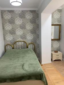 um quarto com uma cama com uma colcha verde em NANO'S APARTAMENt-2 em Kutaisi