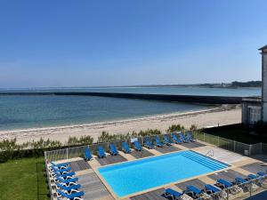 Appartement face mer Le Croisic , piscine privée et plage في لو كروازيك: مسبح وكراسي صالة وشاطئ