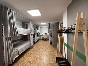 a dorm room with bunk beds and a table at Хостел Житомир GREEN HOUSE in Zhytomyr