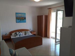 a bedroom with a bed and a sliding glass door at Studio apartmani Ante in Zaostrog