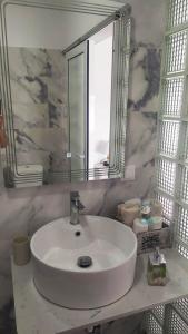 lavabo blanco en el baño con espejo en Odyssia near the Seaside, en Aghios Petros Alonissos