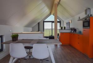 a kitchen with a table and two white chairs at Roggebroek 28 in Stavoren