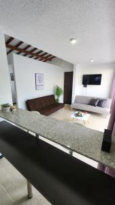 ein Wohnzimmer mit einem Sofa und einer Arbeitsplatte in der Unterkunft Apartasol Club Ciudadela Santa Fe - Santa Fe de Antioquia in Santa Fe de Antioquia