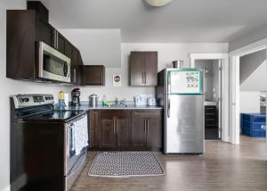 a kitchen with a stainless steel refrigerator and a stove at Separate Suite in Prestigious Linley Valley in Nanaimo