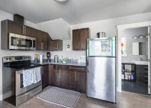 een keuken met een roestvrijstalen koelkast en houten kasten bij Separate Suite in Prestigious Linley Valley in Nanaimo