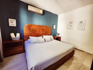 sypialnia z dużym łóżkiem z drewnianym zagłówkiem w obiekcie Casa Mágico Bacalar w mieście Bacalar
