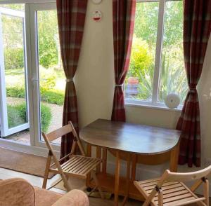 a table and chairs in a room with a window at The Cabin in Hockham