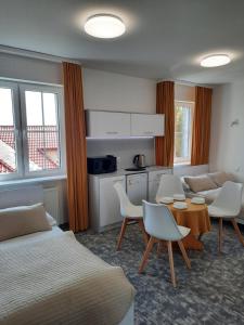 ein Hotelzimmer mit einem Bett, einem Tisch und Stühlen in der Unterkunft Dom Wczasowy KORMORAN Niechorze - 300m od plaży in Niechorze