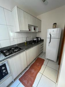 a kitchen with a white refrigerator and a sink at Apartamento Aconchegante no Centro 14 in Toledo