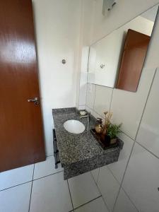 a bathroom with a sink and a mirror at Apartamento Aconchegante no Centro 14 in Toledo