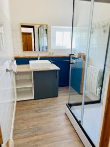 a bathroom with a sink and a shower at La Ferme du Raz Blanchard in Auderville