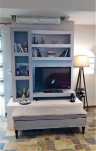 ein Wohnzimmer mit einem großen Flachbild-TV in der Unterkunft Oleander in Eretria