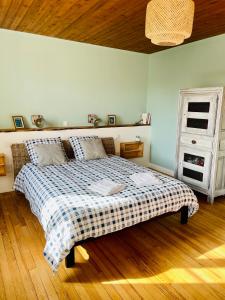 a bedroom with a bed with a checkered blanket at La Ferme du Raz Blanchard in Auderville