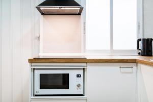 a kitchen with a microwave on a counter at Modern Plaza de Toros Apartment with Free Parking in Granada