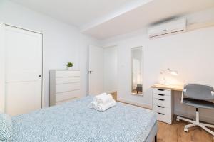 a bedroom with a bed and a desk and a chair at Modern Plaza de Toros Apartment with Free Parking in Granada