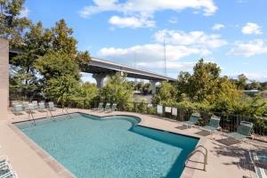 una piscina con sillas y un puente en Nash Gold Condo, 20min Walk to Downtown, 2Bd,2Bth, en Nashville