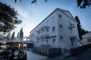 a large white building with a staircase leading up to it at Hotel Bor in Krk