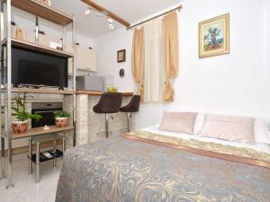 a bedroom with a bed and a desk and a tv at House with swimming heated pool next to the river in Podstrana