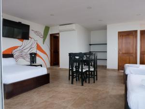 1 dormitorio con 1 cama, mesa y sillas en Margaritas Palace Hotel, en Canoa