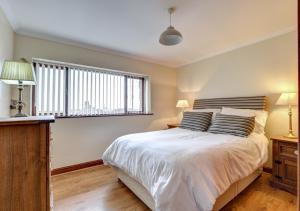 a bedroom with a large bed and a window at Yr Efail in Y Felinheli