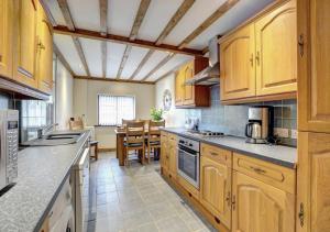 a kitchen with wooden cabinets and a dining room at Yr Efail in Y Felinheli