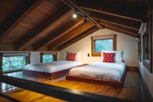 two beds in a room with wooden floors and windows at Fireside Resort in Wilson