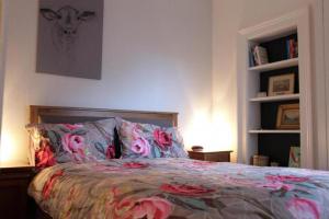 a bedroom with a bed with a floral bedspread at Trendy 2BD flat in West Hampstead in London