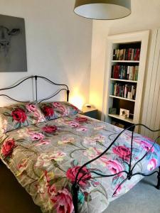 ein Schlafzimmer mit einem Bett mit Blumen darauf in der Unterkunft Trendy 2BD flat in West Hampstead in London