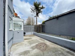 un patio trasero de una casa con una valla en Cosy Bright Studio Apartment Close to Wembley Stadium en Londres