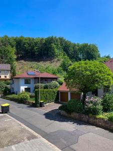 ein Haus an der Seite eines Hügels mit Bäumen in der Unterkunft Kleines Glück zentral mit Balkon und Parkplatz in Gößweinstein
