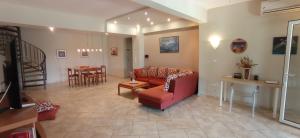 a living room with a red couch and a table at Casa Soare in Nea Kalikratia