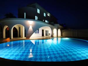 a swimming pool in front of a building at night at Spectacular Villa with Private Pool in Antalya in Belek