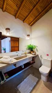 La salle de bains est pourvue d'un lavabo et de toilettes. dans l'établissement Vila dos Macacos Trancoso, à Trancoso