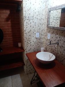 y baño con lavabo blanco y espejo. en Pousada luar da serra en Lumiar