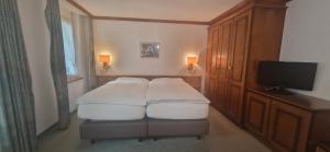 a room with a bed and a tv and a room with at La Perle Apartments in Zermatt