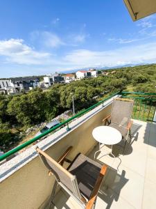 einen Balkon mit 2 Stühlen und einem Tisch auf dem Dach in der Unterkunft Mandre Island Pag in Mandre