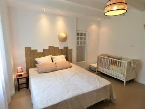 - une chambre avec un lit et un lit bébé dans l'établissement Le petit saou du becq, à Saint-Lon-les-Mines