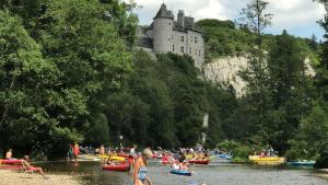 a group of people on boats on a river with a castle at Gites Douillets for the Family in Houyet