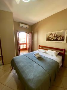 1 dormitorio con 1 cama grande con manta azul en Pousada Paraíso dos Corais, en Arraial do Cabo