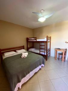 um quarto com uma cama, uma secretária e uma mesa em Pousada Paraíso dos Corais em Arraial do Cabo
