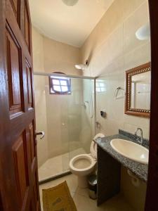 uma casa de banho com um WC, um lavatório e um chuveiro em Pousada Paraíso dos Corais em Arraial do Cabo