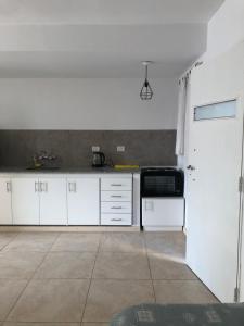 une cuisine avec des placards blancs et une porte blanche dans l'établissement Departamento céntrico a estrenar, à San Juan